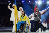 Знаменосец сборной Украины Людмила Павленко в костюме с надписью «мир» на двух языках