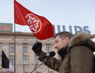 Вице-премьер Рогозин позирует на фоне флага РНЕ на митинге 28 января 2007 года